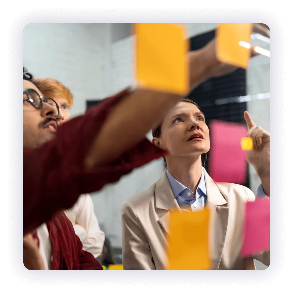 Sessione di brainstorming con post-it colorati su una parete.